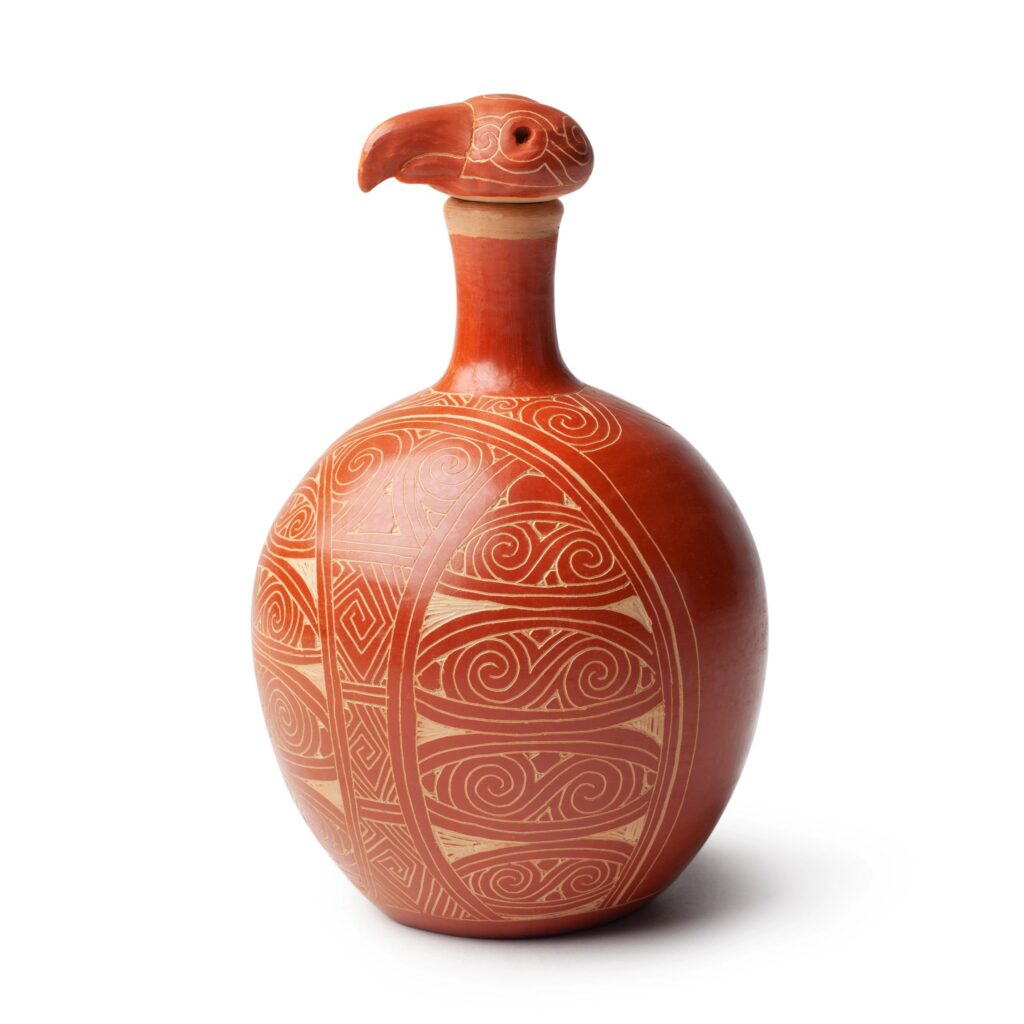 Handmade earthenware jug with bird-shaped cap. The designs are ethnic in origin.